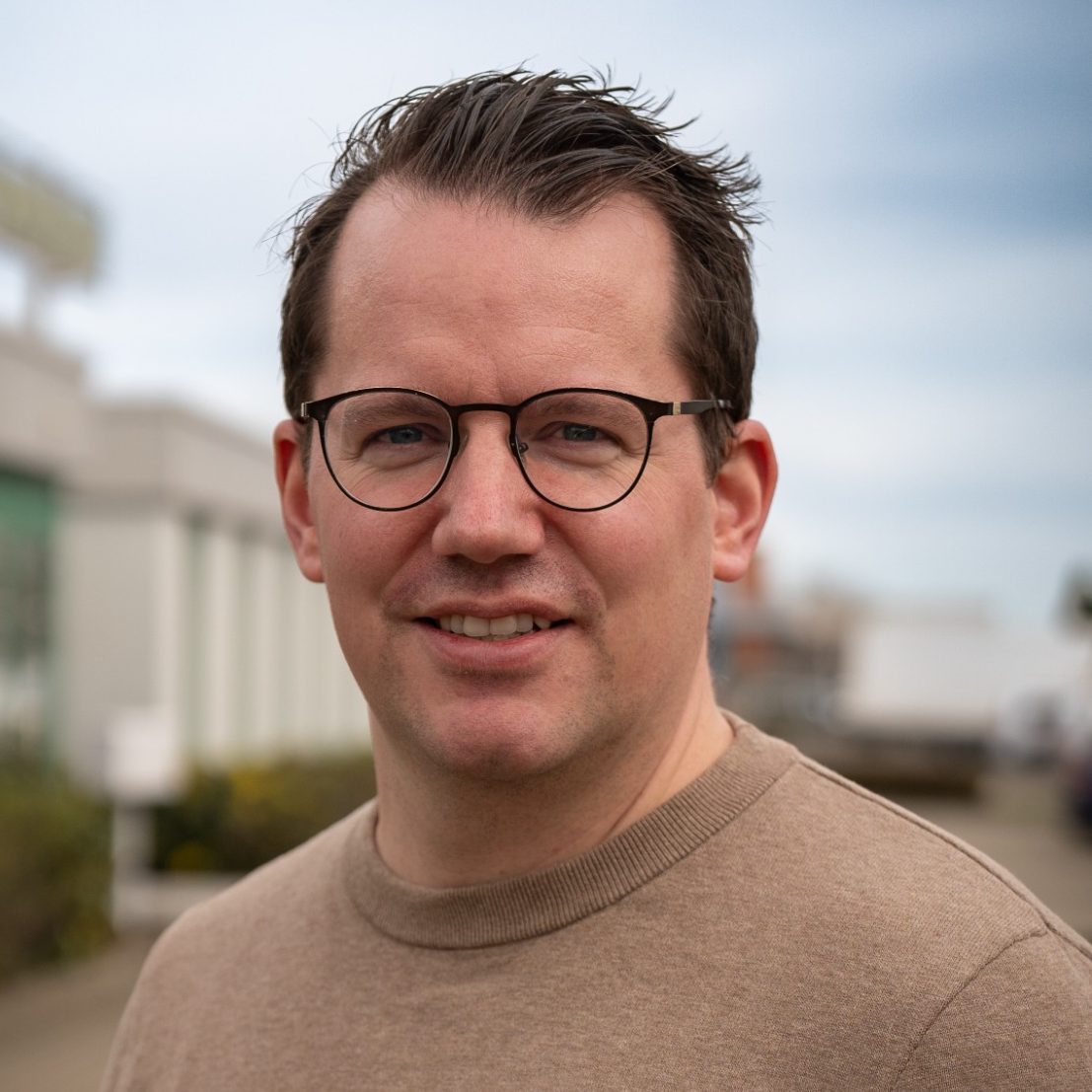 Der Autor des Buchs. Mann mit Brille und hellem Pullover.